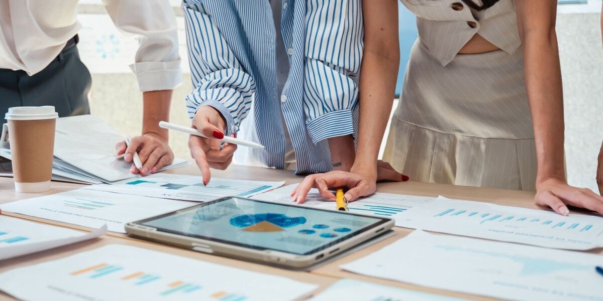 Krisenteam analysiert gemeinsam Daten und Auswertungen an einem Besprechungstisch