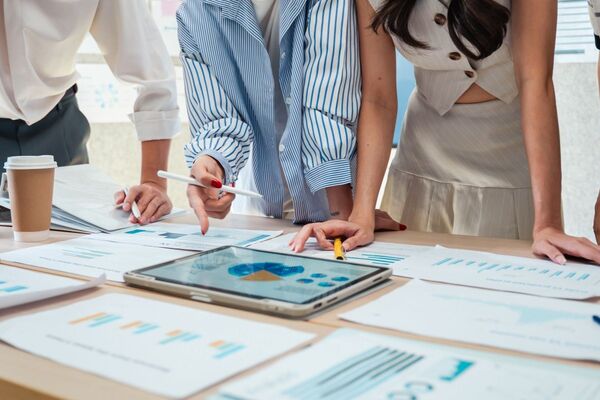 Krisenteam analysiert gemeinsam Daten und Auswertungen an einem Besprechungstisch
